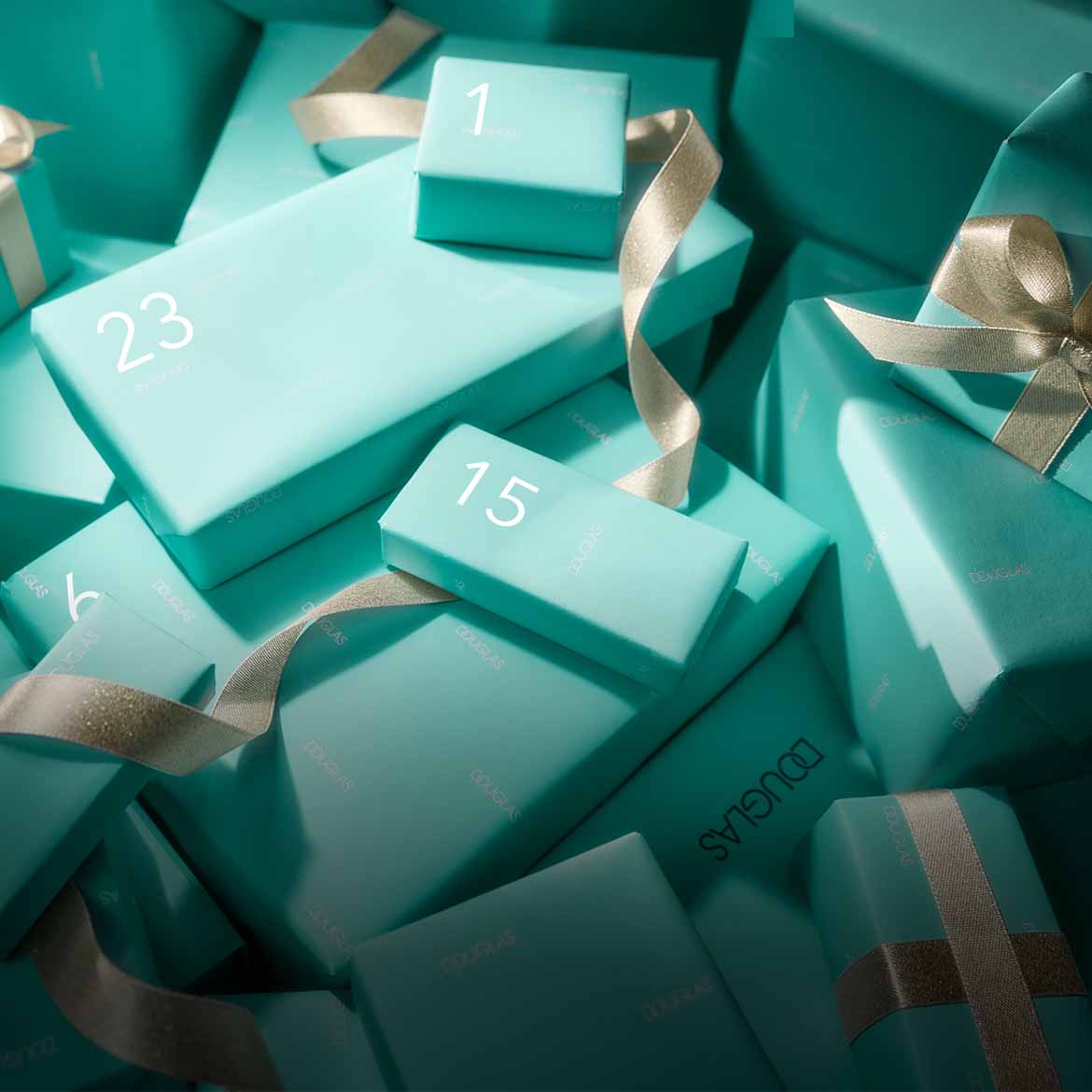 Jasnozielone pudełka z numerami 1, 15 i 23, owinięte złotymi wstążkami, tworzą świąteczny kalendarz adwentowy Douglas.