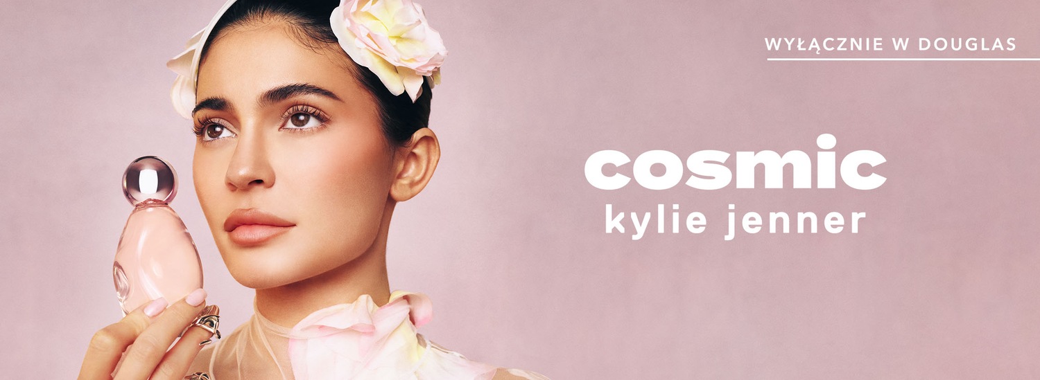 Na tle pudrowego różu, Kylie Jenner prezentuje Cosmic, ekskluzywny zapach dostępny tylko w Douglas, trzymając flakon w kształcie łzy z metaliczną kulką.