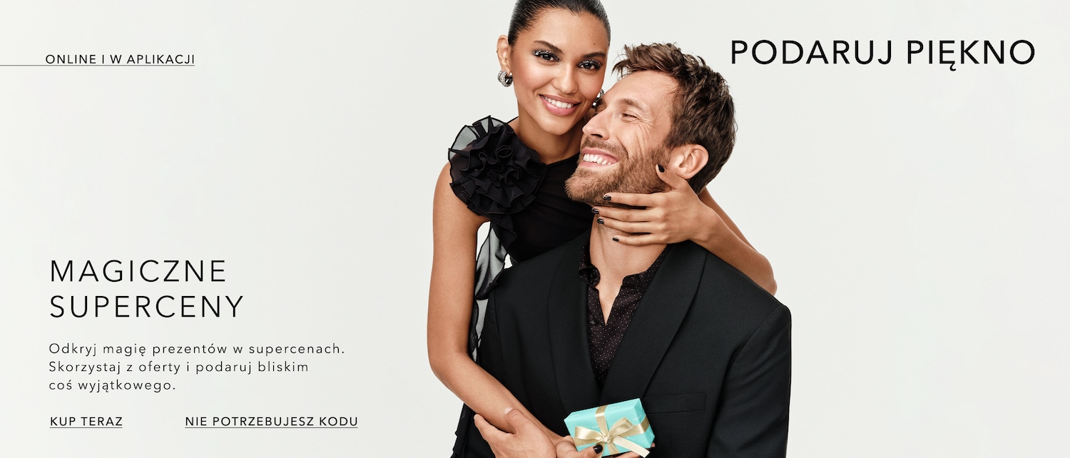 A smiling couple dressed in black attire, with the woman's hand gently placed on the man's neck, holding a small, wrapped gift with a golden ribbon, promoting magical super prices and gifting beauty, available online and in the app. Shop now!
