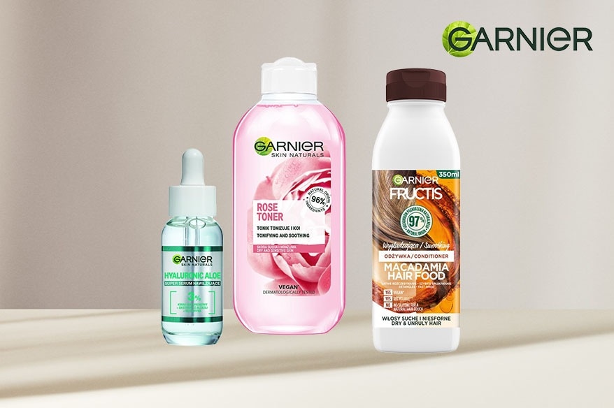 Zestaw kosmetyków Garnier: serum z aloesem i kwasem hialuronowym w przezroczystej butelce, różowy tonik do twarzy oraz odżywka do włosów suchych z macadamią.